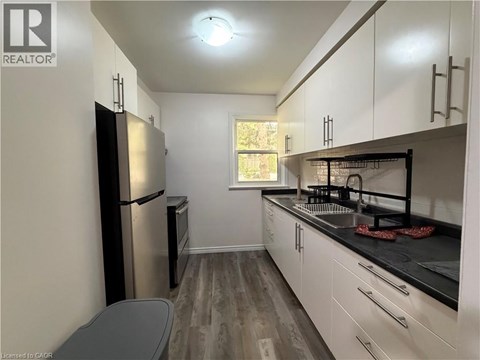 A kitchen with white cabinets and a black countertop.