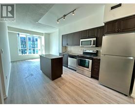 A kitchen with stainless steel appliances and wooden cabinets.