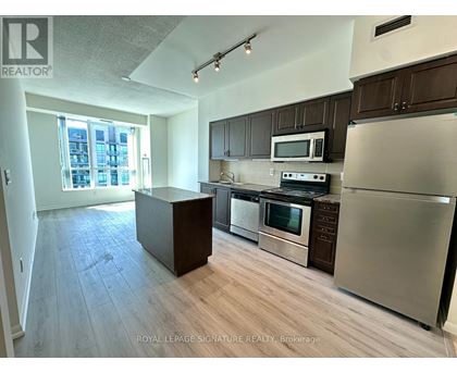 A kitchen with stainless steel appliances and wooden cabinets.