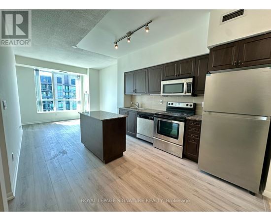 A kitchen with stainless steel appliances and wooden cabinets.