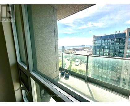 A view from a window of a cityscape with a building in the distance.