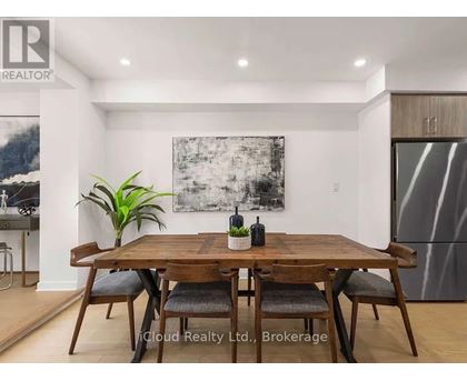 A dining room with a wooden table and chairs.