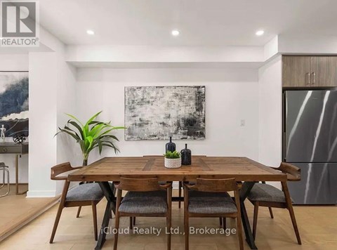 A dining room with a wooden table and chairs.