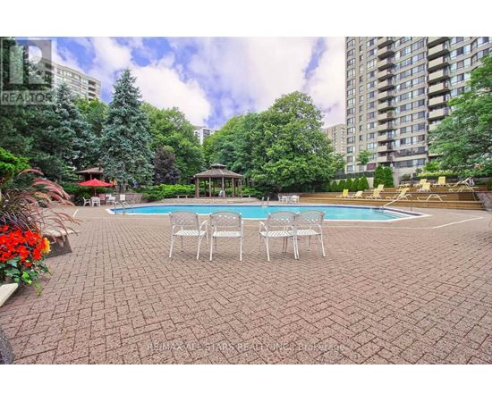 A backyard with a pool and patio furniture.