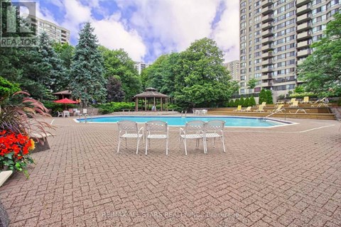 A backyard with a pool and patio furniture.