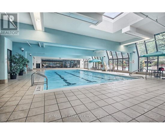 A large indoor swimming pool with a tiled floor and a glass wall.