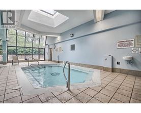 A pool inside a building with a skylight above it.
