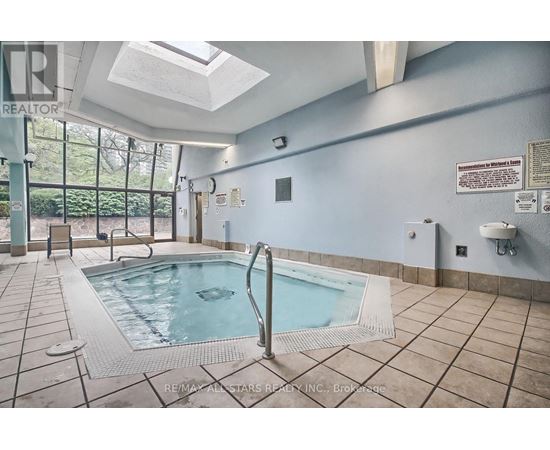 A pool inside a building with a skylight above it.