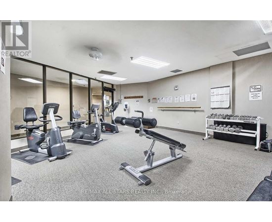 A gym with a variety of equipment including treadmills, stationary bikes, and weight racks.