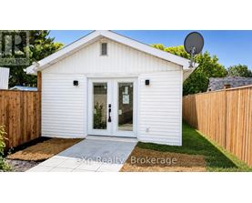 A small white house with a satellite dish on the roof.