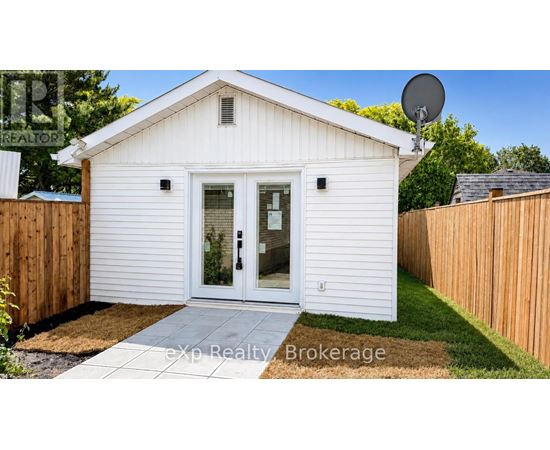 A small white house with a satellite dish on the roof.