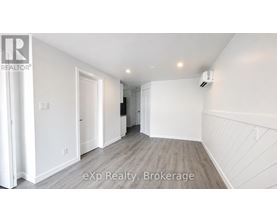 A white room with a brokerage sign on the wall.