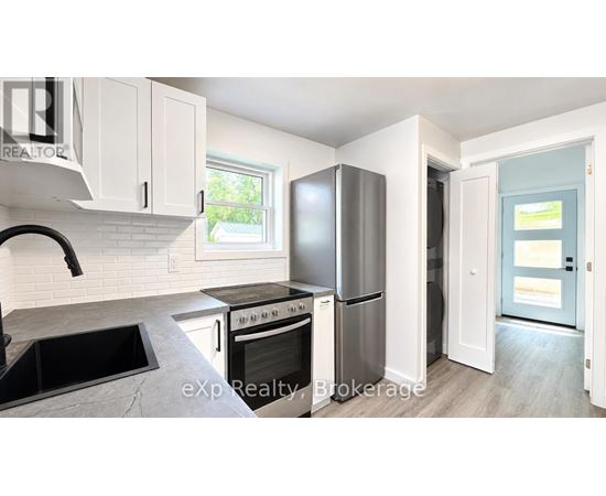 A kitchen with white cabinets and a black countertop.
