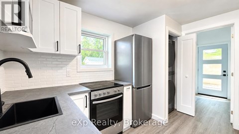 A kitchen with white cabinets and a black countertop.