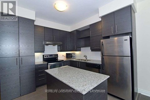 A kitchen with dark wood cabinets and stainless steel appliances.