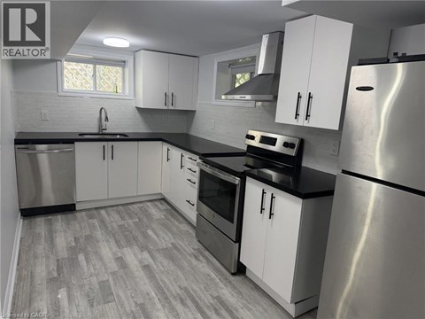 A kitchen with white cabinets and a stainless steel refrigerator.