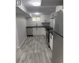 A kitchen with a refrigerator, cabinets, and a countertop.