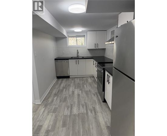 A kitchen with a refrigerator, cabinets, and a countertop.
