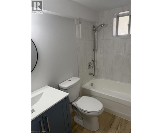 A white toilet sits next to a white sink in a bathroom.