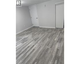 A room with wood flooring and two white doors.