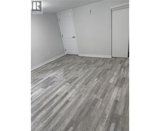 A room with wood flooring and two white doors.