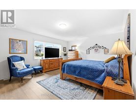 A bedroom with a blue bedspread and a wooden bed.