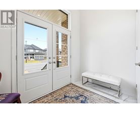 A white door with a glass window is open to a balcony with a bench.