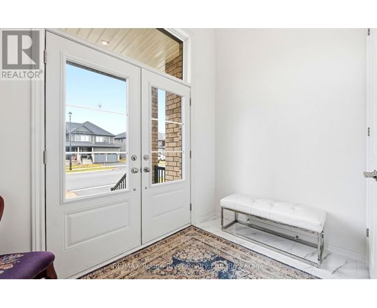 A white door with a glass window is open to a balcony with a bench.