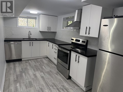 A kitchen with white cabinets and a stainless steel refrigerator.
