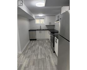 A kitchen with white cabinets and a black countertop.