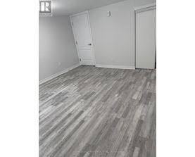 A room with a wooden floor and two white doors.