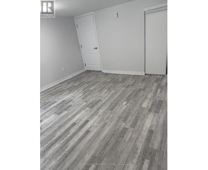 A room with a wooden floor and two white doors.