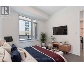 A bedroom with a large bed and a flat screen TV mounted on the wall.
