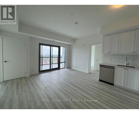 A spacious kitchen with white cabinets and a sink is visible in the image.