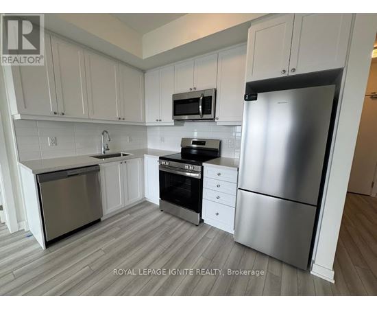 A kitchen with white cabinets and a stainless steel refrigerator.