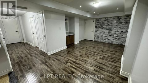 A room with a stone wall and wooden flooring.