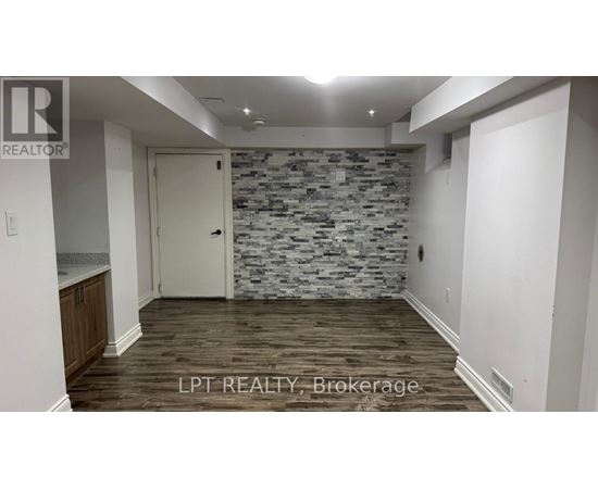 A room with a stone wall and wooden flooring.