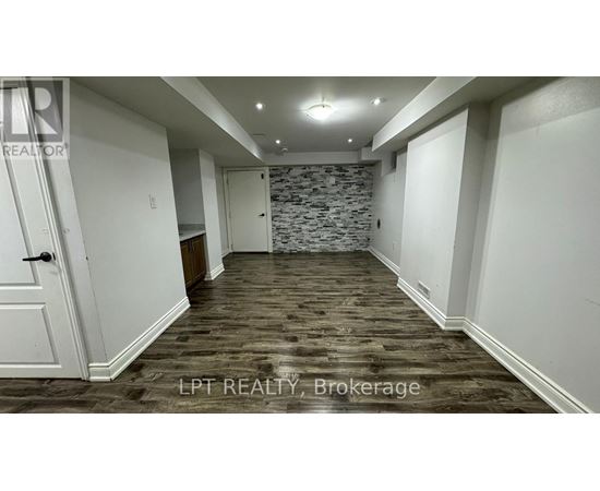 A room with a stone wall and wooden flooring.