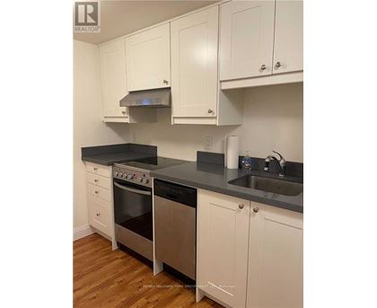 A kitchen with white cabinets and a black countertop.