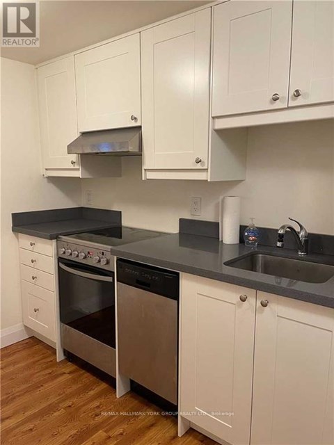 A kitchen with white cabinets and a black countertop.