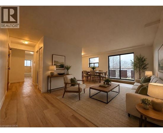 A well-lit living room with a wooden floor and furniture.