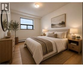 A bedroom with a large bed, a nightstand, and a window.
