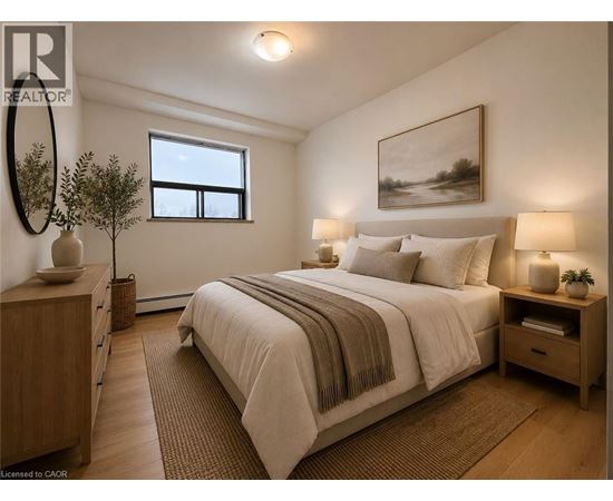 A bedroom with a large bed, a nightstand, and a window.