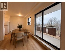 A dining room with a table and chairs and a large window.