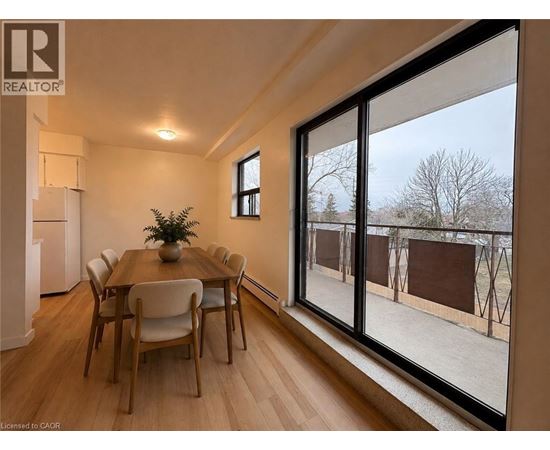 A dining room with a table and chairs and a large window.
