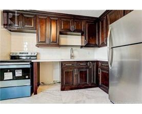 A kitchen with wooden cabinets and a refrigerator.