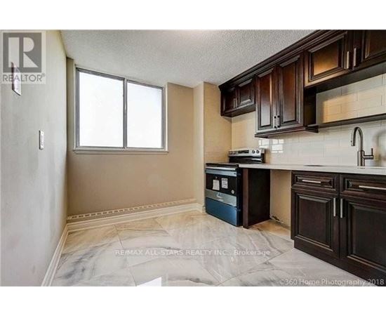 A kitchen with brown cabinets and a white fridge.
