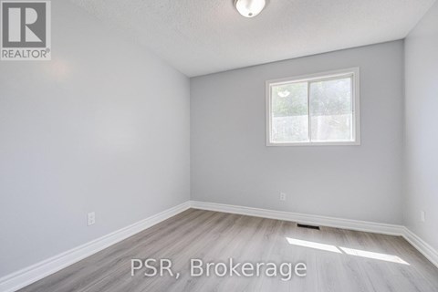 A room with a window and a wooden floor.