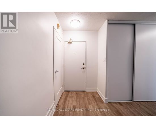 A white door is in a room with a wooden floor.