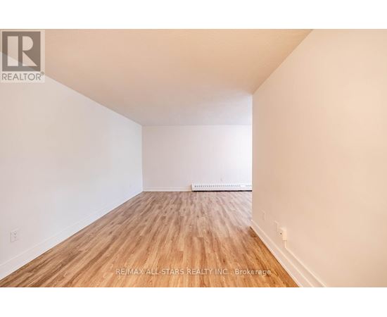 A room with wooden flooring and white walls.